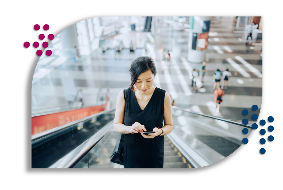 Woman looking at phone on escalator.